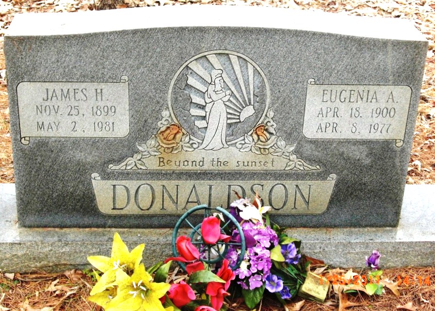 Marble headstone for James H. Donaldson with a bouquet of flowers in front of it. 